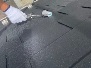 世田谷区 綺麗な黒い屋根に下塗りをしている